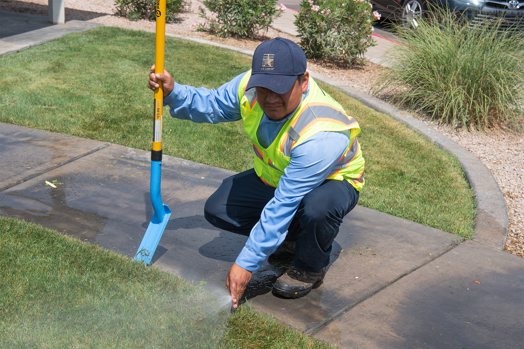 Technician checking a sprinkler head during commercial irrigation service in Phoenix, Chandler and Scottsdale, AZ