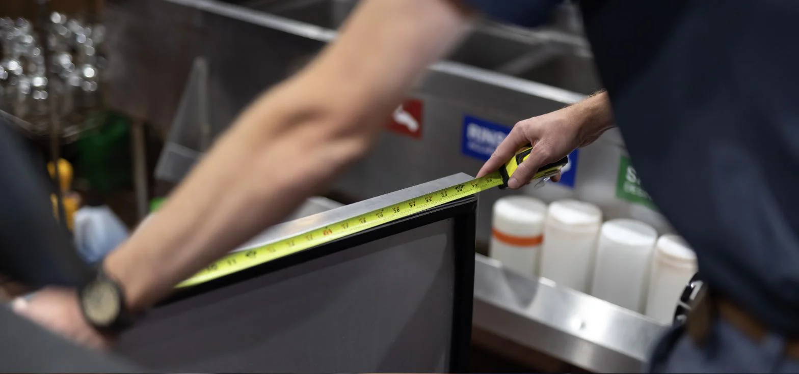 Technician measuring a commercial refrigeration door gasket